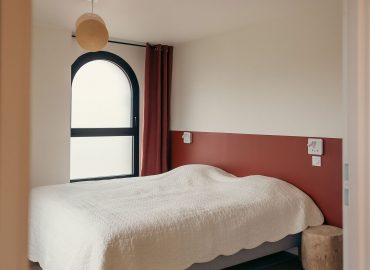 Une chambre avec un lit double accès PMR